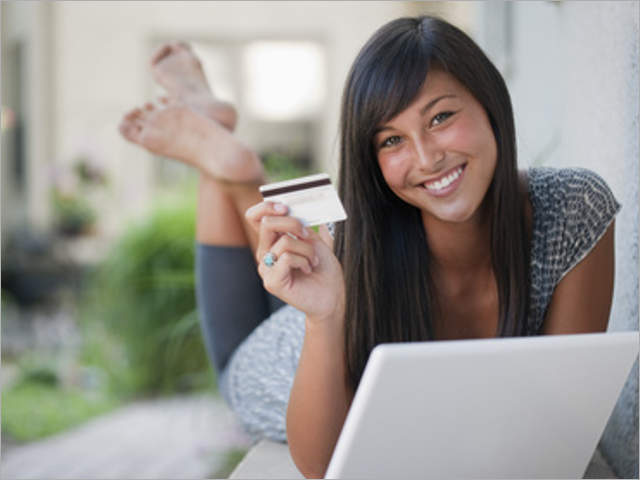 Teenage girl shopping online with credit card and laptop